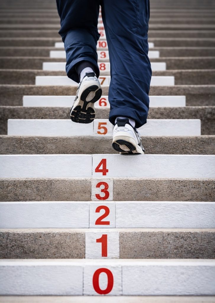 Person climbing stairs representing growth and progress